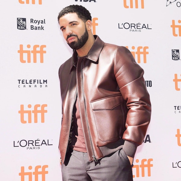 Drake pose devant un mur recouvert de logos du TIFF.