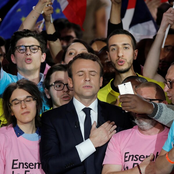 Emmanuel Macron entouré de partisans portant des chandails avec son slogan de campagne "Ensemble la France".