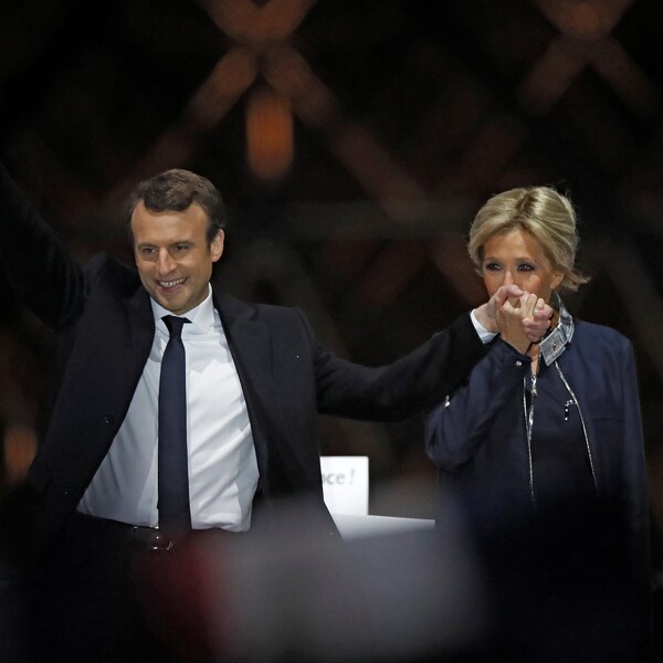 Le nouveau président de la France Emmanuel Macron et sa conjointe Brigitte Trogneux accueillant la victoire devant les partisans réunis au Musée du Louvre.