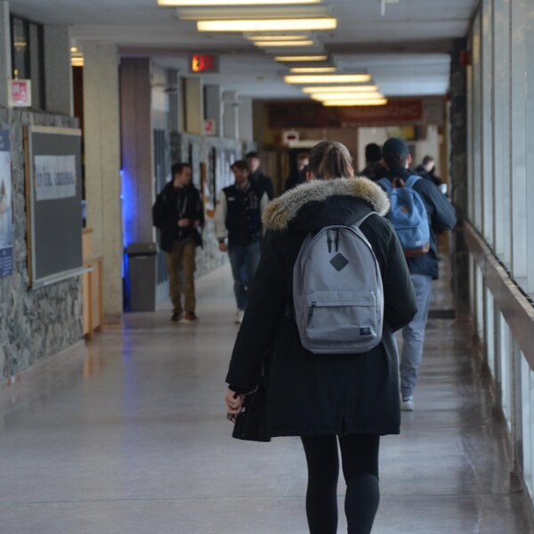 Des étudiants marchent dans le corridor du campus universitaire de la Laurentienne dans le Grand Sudbury. 