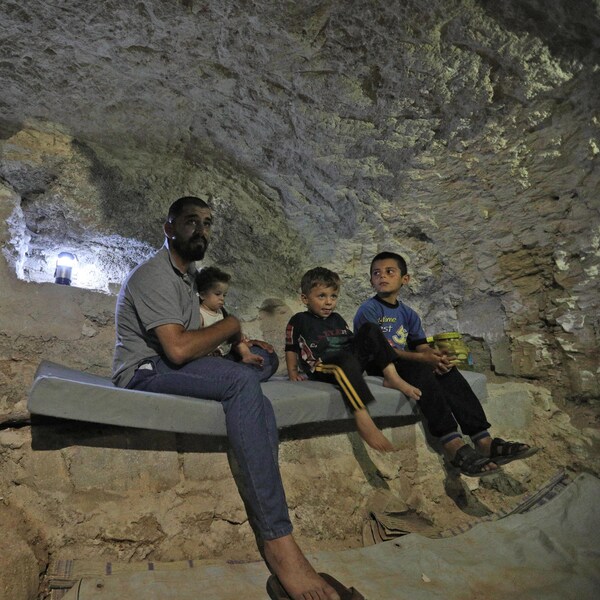 Hadheefa al-Shahadh est assis avec ses trois enfants dans un abri qu’il a creusé à l’intérieur de sa maison afin de protéger sa famille dans le village de Maar Shurin, le 11 septembre 2018.