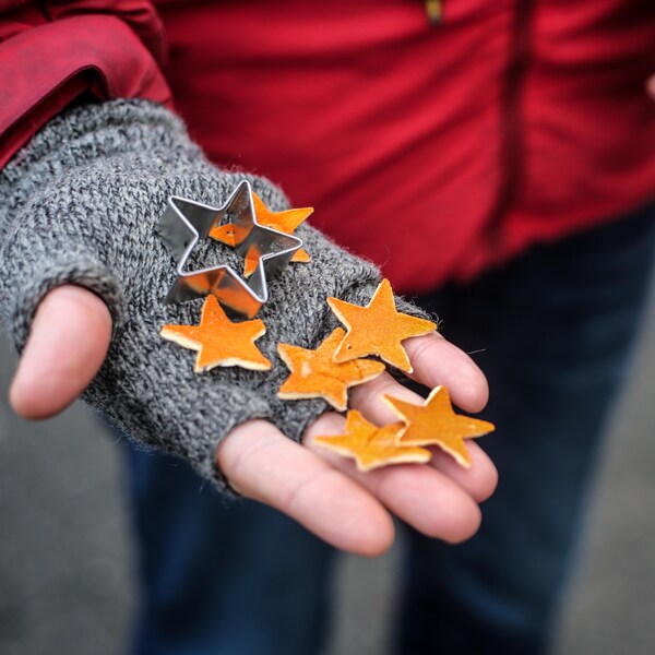 Des étoiles fabriquées à partir de pellures d'orange dans la paume d'une main. 