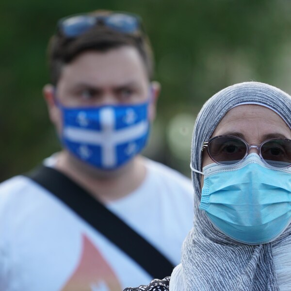 Une femme de confession musulmane porte un masque lors d'une veillée à la chandelle.