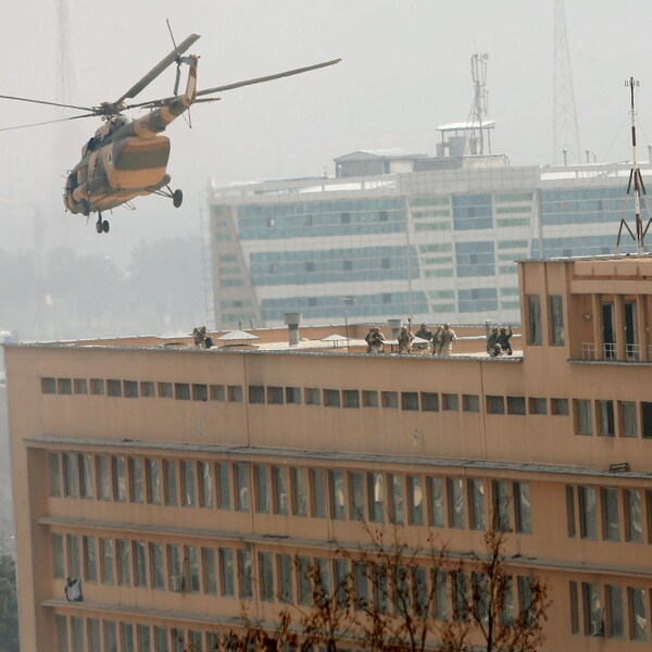Les forces de sécurité afghanes sont intervenues dans l'hôpital après avoir été déposés sur le toit par un hélicoptère de l'armée. En bas, à gauche, on peut voir des gens ayant trouvé refuge sur le bord d'une fenêtre. 