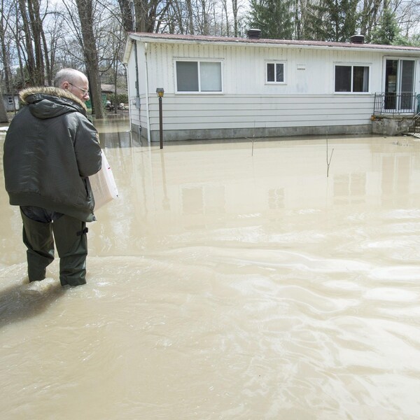 Alain Bélanger, un sinistré, marche vers sa maison inondée à Rigaud.