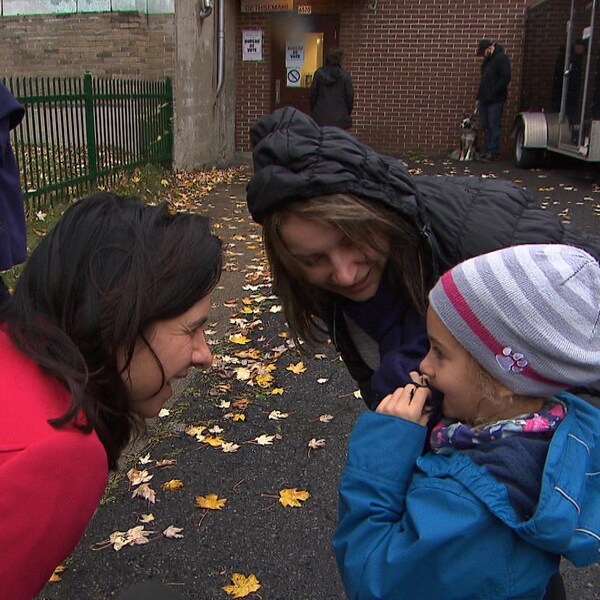 Valérie Plante (à gauche) s'entretient avec une mère (au centre) qui accompagne son enfant (à droite) au « petit bureau de vote » dans un arrondissement de Montréal le 5 novembre 2017.