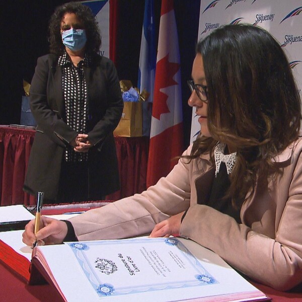 Julie Dufour signe un document officiel.
