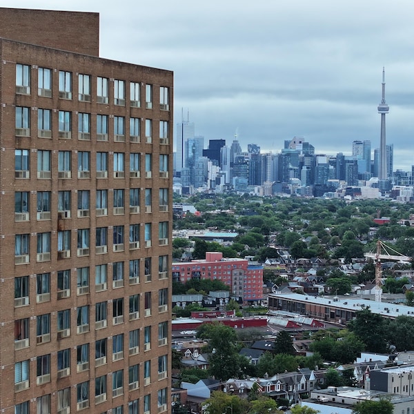 Un grand immeuble à appartement vue des airs, avec le centre-ville de Toronto à l'arrière.