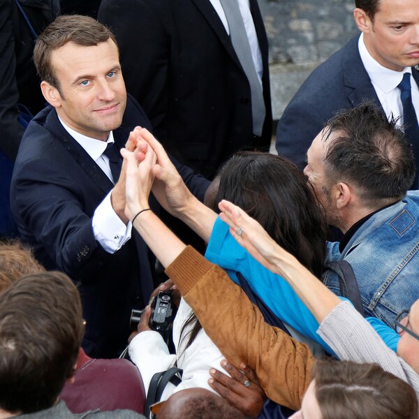 Le président français sert la main de passants à l'Arc de Triomphe.