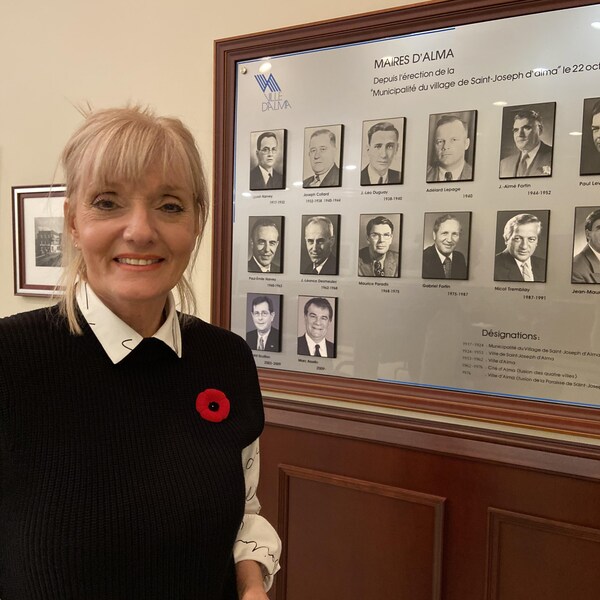 On aperçoit la mairesse de la ville, Sylvie Beaumont, souriante, devant l'encadré mural présentant les anciens maires de la ville.