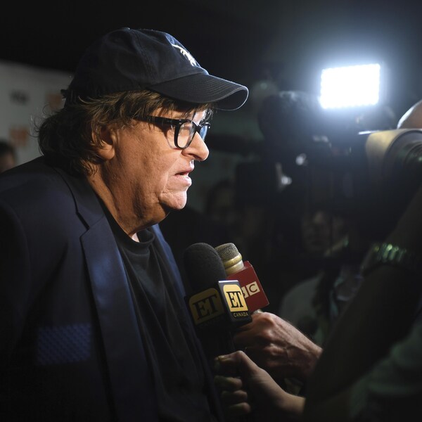 Le réalisateur américain Michael Moore répond aux questions des journalistes sur le tapis rouge du TIFF.