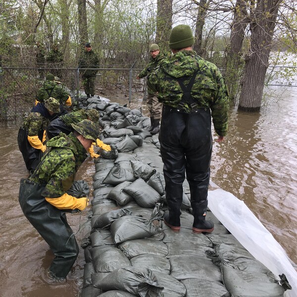 Des militaires travaillent à consolider une digue dans un secteur de Pierrefonds, à Montréal