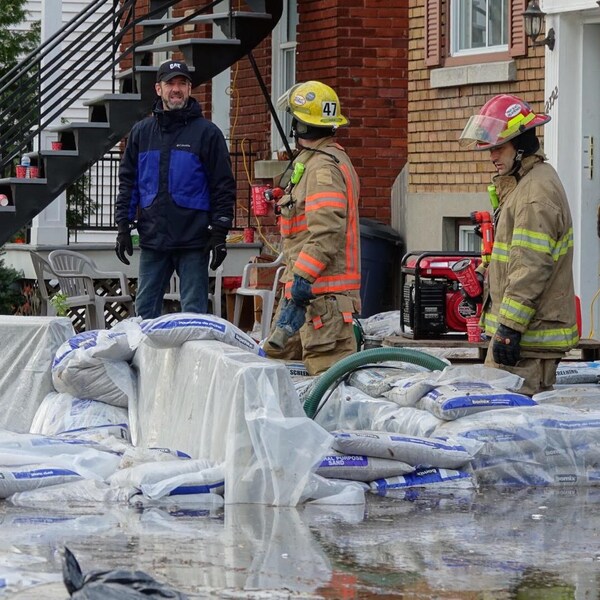 Des pompiers aident des sinistrés à Montréal.