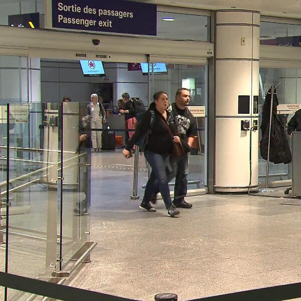 Des gens sortent par la sortie des passagers à l'aéroport Montréal-Trudeau.