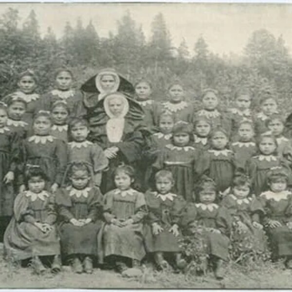 Une photo de classe avec des jeunes filles autochtones entourées de religieuses. 