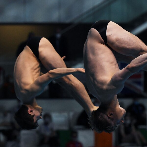 Deux athlètes qui réussi un plongeon synchronisé.