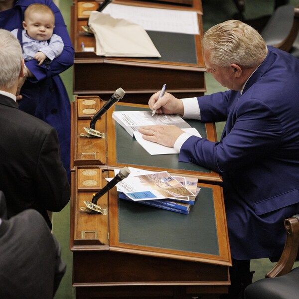 Le premier ministre de l'Ontario, Doug Ford, signant une copie du budget