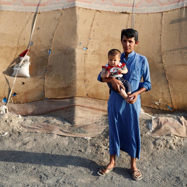 Un homme et son enfant chassés par les combats à Raqqa vivent dans une tente en plein désert.