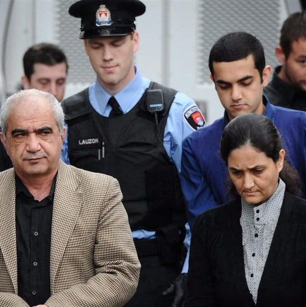Les trois membres de la famille Shafia sont escortés par des policiers vers l'entrée du palais de justice de Kingston, le 20 octobre 2011.