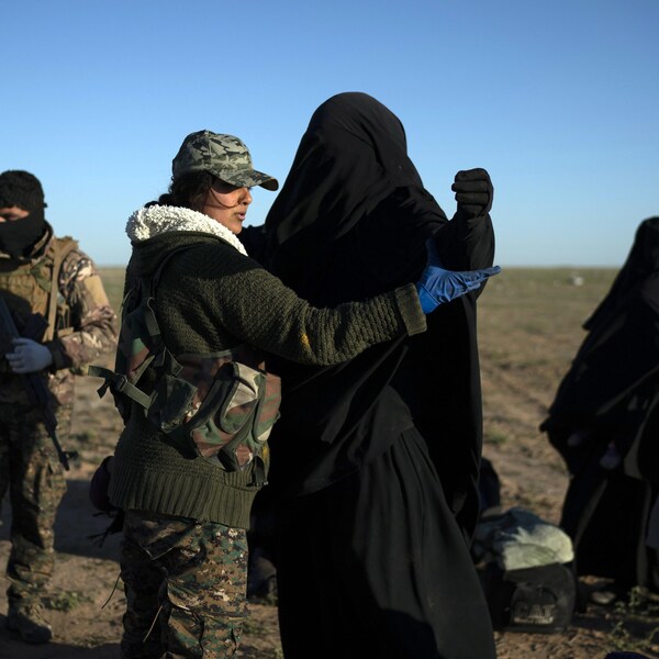 Une membre des Forces démocratiques syriennes fouille une femme qui a été évacuée de la dernière zone sous contrôle de l'État islamique, en Syrie.
