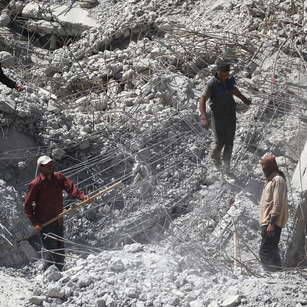 Des travailleurs creusent le sol à travers les ruines à Raqqa, le 18 avril 2018. 