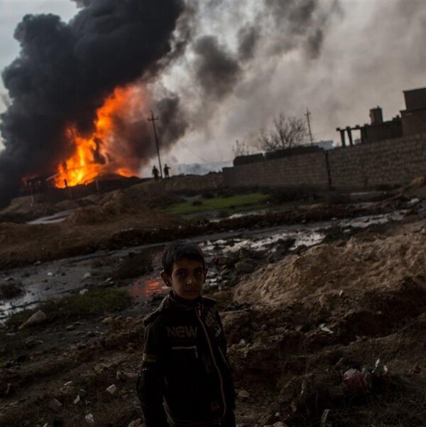 Un enfant irakien devant un puits de pétrole en feu à Al-Qayyarah, près de Mossoul.