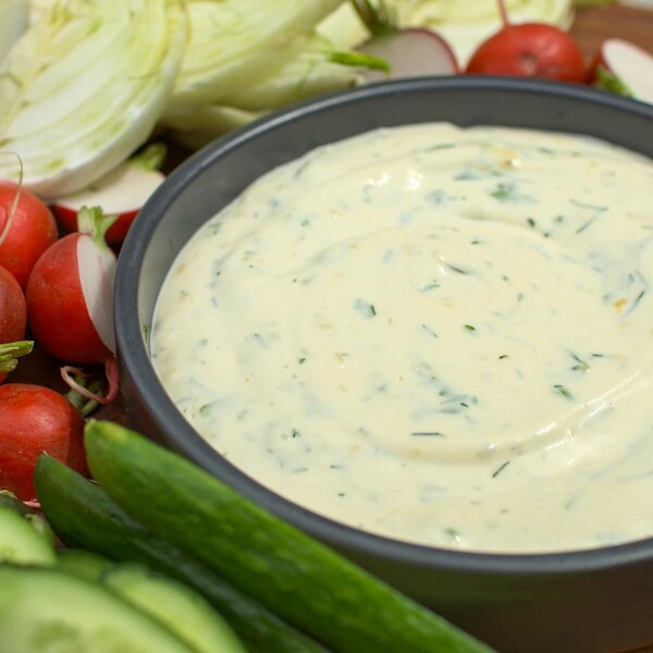 Un bol de trempette traditionnelle Ranch à base de crème sûre accompagné de crudités.