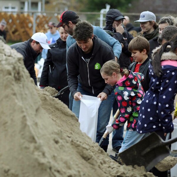 Le premier ministre Justin Trudeau remplit un sac de sable à Terrasse-Vaudreuil, au Québec.