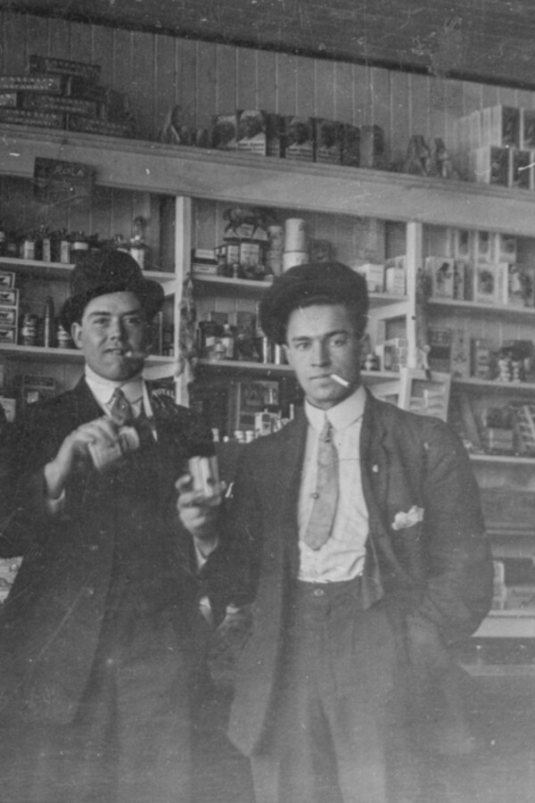 Alexander Bourassa, Frederick Plamondon, Arthur Bourassa et Benoit Plamondon buvant et fumant à l'intérieur du magasin Plamondon vers 1920. 