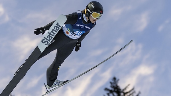Une athlète de saut à ski effectue un saut