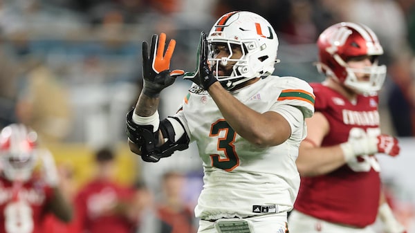 Un joueur de football fait un U avec ses mains après avoir plaqué un adversaire.