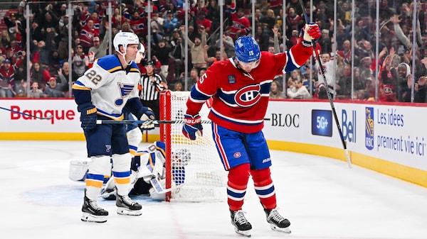 Un joueur de hockey des Canadiens de Montréal célèbre un but devant des joueurs des Blues de St. Louis.