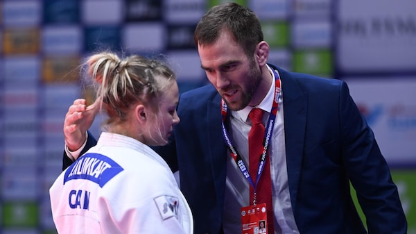 Un entraîneur console une judoka triste, après sa défaite. 
