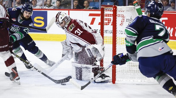Jared Davidson et Dylan Guenther des Thunderbirds tentent de marquer.