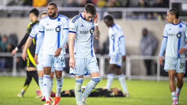 Des joueurs de soccer qui ont l'air dépité sur le terrain.