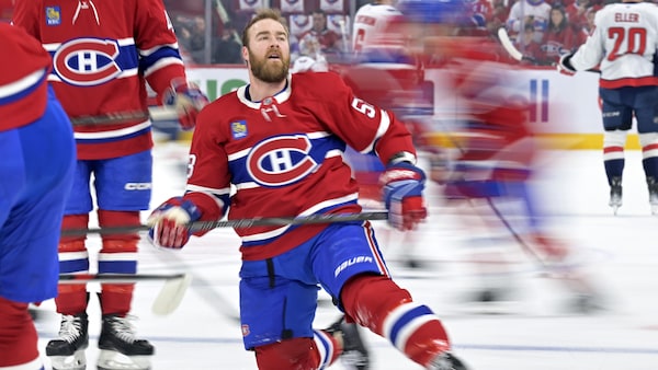 Il s'étire, un genou sur la glace, au milieu de ses coéquipiers.