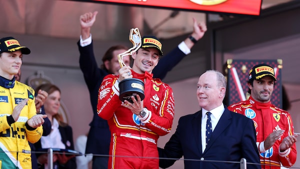 Charles Leclerc tient son trophée sur le podium, aux côtés du Prince Albert II de Monaco.