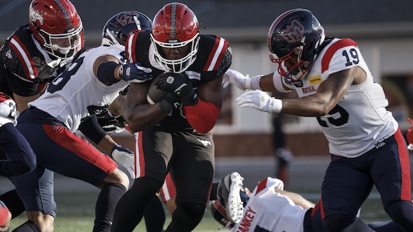 Kabion Ento et Geoffrey Cantin-Arku tentent de retenir le porteur de ballon des Stampeders, Dedrick Mills.