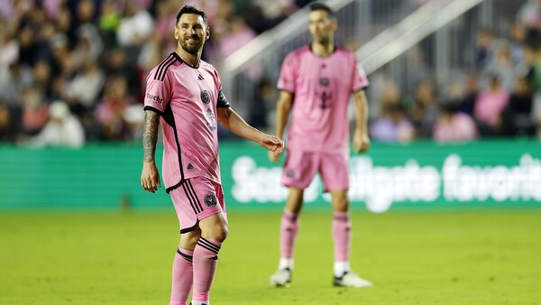 Le joueur de soccer Lionel Messi sourit en se tournant la tête.