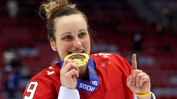Une joueuse de hockey mord dans une médaille. 