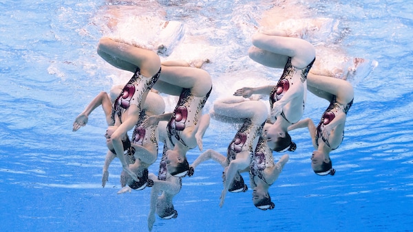 Des nageuses artistiques effectuent une figure sous l'eau.