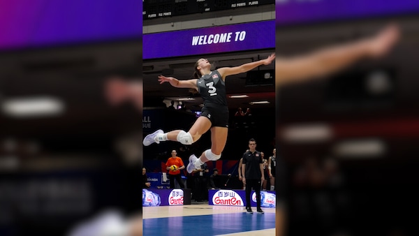 Kiera Van Ryk saute dans les airs pour servir pendant un match.