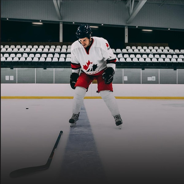 Le journaliste Michaël Roy se tient debout sur une patinoire vêtu d'un équipement de hockey.