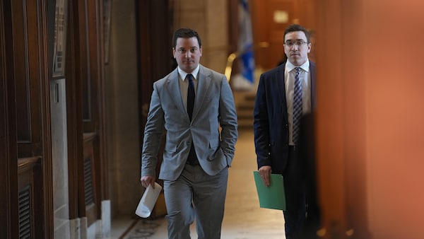 Simon Jolin-Barrette marche dans un corridor de l'Assemblée nationale en compagnie d'un autre homme.