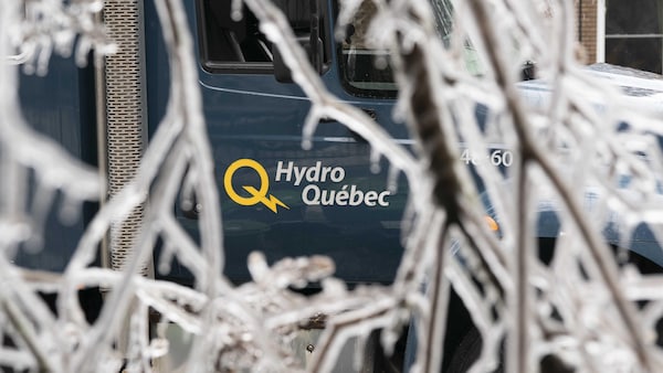 Un camion d'Hydro-Québec, au travers de branches couvertes de verglas.