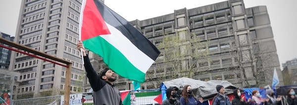 Des manifestants portant le drapeau israélien rassemblés autour de photos des otages du Hamas.