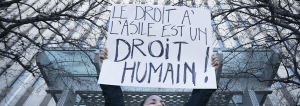 Une manifestante réclamant de respecter les droits des demandeurs d'asile lors d'une manifestation devant les bureaux de circonscription du premier ministre Justin Trudeau.
