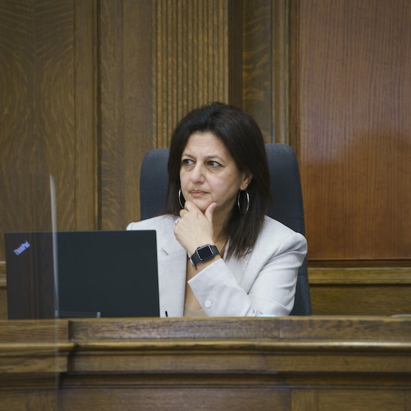 Une femme assise dans une salle d'un palais de justice.