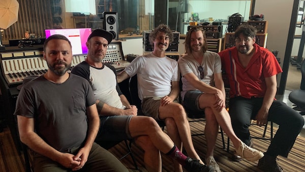 Les cinq musiciens du groupe Karkwa dans un studio d'enregistrement.