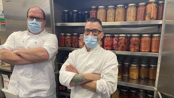 Virgile Lafrenière et Pascal Larouche, le duo de cuisiniers appelé les Chacals, devant les conserves au CHSLD Éloria-Lepage.
